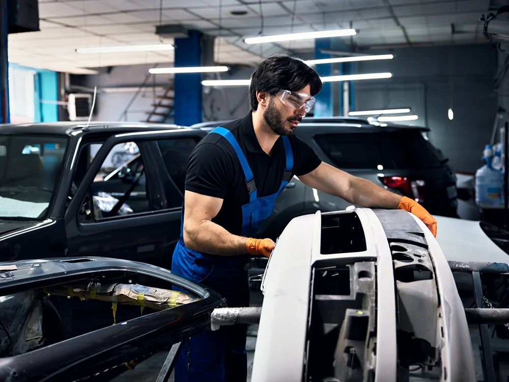 A technician fitting a replacement bumper cover