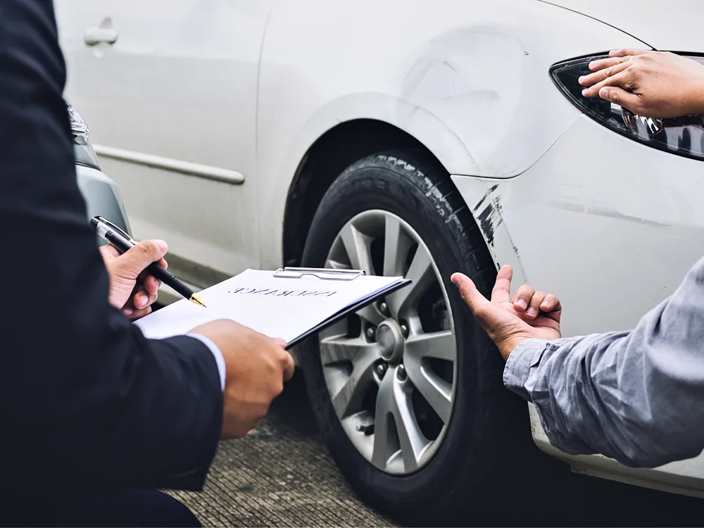 An adjuster assessing damage to a vehicle